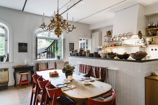 A Visual Journey Through Stockholm's Hotel Ett Hem - Photo 3 of 12 - The communal kitchen rotates around a farm table where guests can relax while chefs prepare meals. Ett Hem only uses fresh, local ingredients that change according to the season. Each morning, the staff chooses what the meals will be and they leave pastries, champagne, wine, and other treats for guests to grab throughout the day.