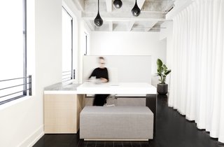 This New Jewelry Showroom Celebrates 'Made in L.A.' From Top to Bottom - Photo 1 of 9 - The custom appointment desk was designed and built with a single bent sheet of aluminum, lacquered MDF, marble, and white oak. The floor-to-ceiling white curtain hides the built-in kitchen that was part of Lee's loft from the beginning.