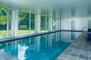A Thomas Phifer-Designed Glass-and-Steel Masterpiece For Sale - Photo 11 of 14 - The substructure features an indoor pool, which looks out through glass walls on the side that's exposed to the ground level. 
