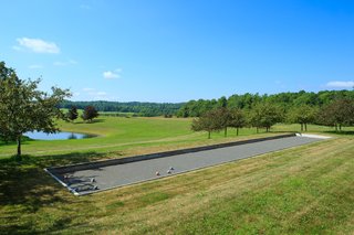 A Thomas Phifer-Designed Glass-and-Steel Masterpiece For Sale - Photo 13 of 14 - Along with a tennis court, the property also features a bocce court, which sits adjacent to the outdoor pool.