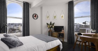 Gin Enthusiasts Will Be Flocking to This New London Hotel - Photo 2 of 7 - The three boutique guest rooms feature a combination of midcentury furniture and playful, spirit-inspired accents. Designed by the brand’s founding directors, each room includes a minibar filled with spirits that have been crafted on-site, as well as a bespoke record player with a vinyl playlist that’s been curated by Rough Trade Records.