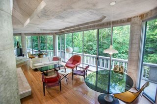 The One-of-a-Kind Home of the Late Architect John Black Lee Drops to $750K - Photo 7 of 10 - The interior hosts an open floor plan and looks out over a balcony that runs the length of the structure along the river side. 