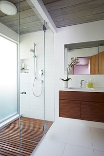 The larger master bathroom was reoriented and updated with new materials—the same ones that have been used throughout the house, including walnut and Western red cedar siding. 