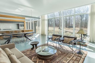 Taking a peek into the combined living area at the center of the house shows the kitchen that’s made up of the same red cedar that’s used throughout the home—as well as laminate marble. 
