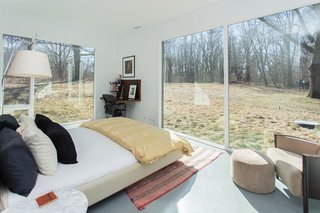 The bedrooms enjoy views of the wooded surroundings through large expanses of glass. 