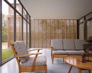 Shown here is the screened porch that looks out through glass on one side and screened red cedar slabs on the other. 