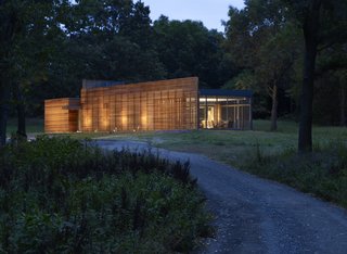 The Coffou Cottage sits in an L-shaped configuration at the end of a private road. This image shows how red cedar is utilized to create thin slats along the facade, as well as horizontal and vertical board-and-batten siding.