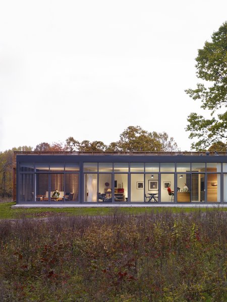 10 Enclosed Porches That Are Put to Good Use - Photo 4 of 10 - The glass-enclosed side of the house looks into a screened porch on the left, followed by a combined open space that brings together the living space, dining area, and the kitchen.