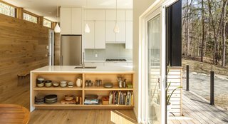 This Cedar-Wrapped Cabin Mimics its Natural Surroundings With Ease - Photo 2 of 3 - The interior consists of a mixture of white oak boards, slabs of silver maple, and encased steel. Clerestory windows line the space, providing a clear lookout to the forested surroundings. 