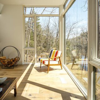 This Cedar-Wrapped Cabin Mimics its Natural Surroundings With Ease - Photo 1 of 3 - The family room is shown here in the cantilevered upper level, while the lower level holds the sleeping quarters and a recreation room. 