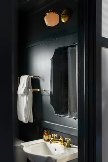Modern Equestrians Will Find Themselves at Home at This New Americana Hotel - Photo 5 of 7 - In the moody bathrooms, you’ll find solid brass fixtures, rain showers, chamfered mirrors, and products from C.O. Bigelow Apothecaries. 