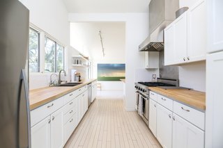 If You Crave Bright, Light-Filled Spaces, This Midcentury Home For Sale Could Be the One - Photo 4 of 9 - While the kitchen was updated with new surfaces and appliances, its original wood flooring has been kept intact.
