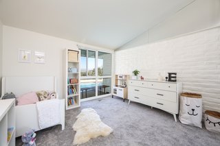 If You Crave Bright, Light-Filled Spaces, This Midcentury Home For Sale Could Be the One - Photo 8 of 9 - The bedroom that the current family turned into their daughter’s room has one original brick wall and looks out to views of the pool. 