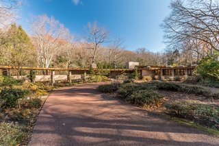 Frank Lloyd Wright’s Last Major Residential Masterpiece Could Be Yours for $8 Million - Photo 1 of 11 - From the front of the house, you can see that Tirranna was designed in a hemicycle shape, which Frank Lloyd Wright was known for. The main entrance to the house sits under the chimney stack near the center, while the covered breezeway on the left leads to a four-car parking structure, the greenhouse, and the caretaker’s quarters. 