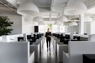A San Francisco Design Collective Reveals its Impeccably Cool Creative Studio - Photo 4 of 12 - The central open work area is filled with white standing desks made by Muller Nichols, which sit under large dome pendants by FontanaArte.