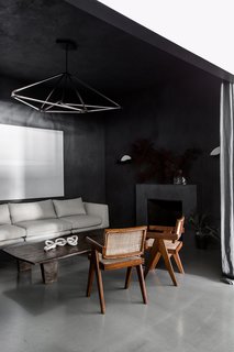 A San Francisco Design Collective Reveals its Impeccably Cool Creative Studio - Photo 1 of 12 - When you first enter the space, you step into a moody entry salon with hand-applied Italian integral color plaster walls and a marble fireplace. Designed to feel welcoming and residential, it’s furnished with midcentury armchairs and a dramatic hanging light fixture by Bec Brittain.