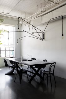 A San Francisco Design Collective Reveals its Impeccably Cool Creative Studio - Photo 7 of 12 - To create a place where employees and visitors can have family style lunches, they brought in a large dining table by James Perse. The hanging light is Lampada 046 by Dimore Studio.