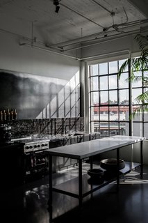 A San Francisco Design Collective Reveals its Impeccably Cool Creative Studio - Photo 8 of 12 - Directly next to the dining area is the dark kitchen, which has a custom island that's made with a metal base and a CoorItalia Calacatta marble top. Designed by Chris French, it’s designed to invite socializing.