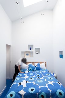The cut-outs were added into the bedroom walls while the bed is outfitted with one of Marimekko's classic duvet covers.