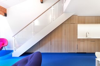 The custom cabinetry is made with bleached rift-cut white oak and is finished with mirror pulls. Created by David Amble Cabinetry, the cabinets were designed to be put to serious use—one holds extra folding dining chairs while another hides a Murphy bed.