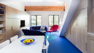 Though all the surfaces were updated throughout the space, Simon preserved the structural beams overhead. The Ploum sofas—designed by Erwan and Ronan Bouroullec for Ligne Roset—are upholstered in a cobalt blue quilted blend fabric, while the Womb Chair—designed by Eero Saarinen for Knoll—is finished with a bold magenta fabric.