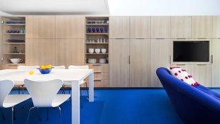 Because of the loft’s specific layout, they decided to maximize the space by creating as much storage as possible on the available walls. Shown here is one of the walls that’s lined with flush-mounted cabinets by David Amble Cabinetry. The dining table is surrounded by Arne Jacobsen Series 7 Chairs.