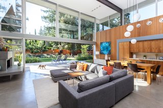 A Year of Careful Study Leads to a Thoughtful Renovation of a 1949 Eichler - Photo 1 of 10 - The double-height great room encompasses much of the renewed section in the middle of the home—which includes the living, dining, and kitchen spaces. Since the existing floor slabs had developed cracks, Jay and Melissa floated new concrete floor slabs over the existing ones. They replicated the original flooring as close as possible, and polished the final result. 