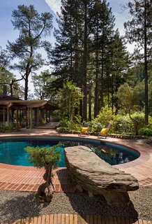The Midcentury Home That Daniel Liebermann Built For His Parents Asks $2.8 Million - Photo 14 of 16 - A huge rock that Liebermann picked out himself acts as a diving board into the pool. Liebermann's design allows the house to reflect in the pool when you first walk in through the front gate. The reflection doubles the size of the house. 