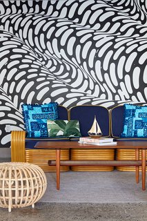 This Surf-Inspired Hotel Celebrates Waikiki’s Creative Spirit and its Midcentury Roots - Photo 3 of 13 - In the covered cabana area by the pool, a hand-painted mural by Brendan "The Blob" Monroe creates a funky backdrop that's inspired by the flow of water. Local artist, illustrator, and curator Jasper Wong co-curated the mural artwork dispersed throughout the property.