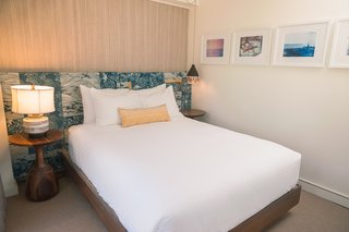 This Surf-Inspired Hotel Celebrates Waikiki’s Creative Spirit and its Midcentury Roots - Photo 11 of 13 - The bedrooms are graced with headboards that Studio Collective created with vintage Tori Richard prints. The dreamy framed surf photography on the wall is by She Hit Pause Studios.