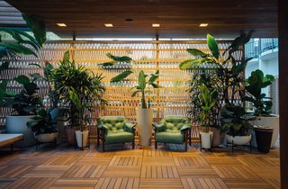 A 100-foot-long wall of terra-cotta breeze blocks designed by Patricia Urquiola for Mutina surrounds the reception desk and extends into a seating area.