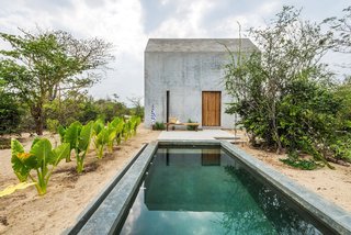 The minimalist structure is made of concrete and features wooden accents, which add rustic warmth to the interior. 