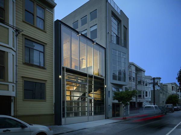 The smooth glass street façade de-materializes the dense urban fabric, creating a shimmering void reflecting the sky by day and a glowing interior by night - seamlessly integrating vehicular and pedestrian “drive through” access from Minna Street to the rear yard.
#evening #facade #sanfrancisco #workshop #interstice #intersticearchitects #cesarrubio #cesarrubiophotography Photo 2 of Minna Street DREAM:shop modern home