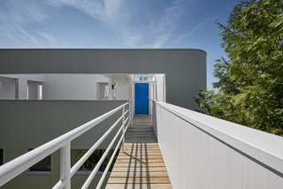The main entry, accessed via a footbridge that extends beyond the building envelope and into the site, leads to the upper-level floor. "It is truly a house of opposites," said the architect. "To leave the house, for instance, you go up instead of down."