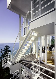 A series of ladders and cantilevered staircases connect each level of home from the exterior, offering a dramatic cascading promenade with an expansive view of Lake Michigan.