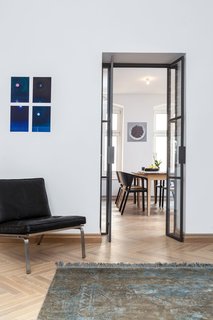A Hidden Passageway Makes Each Room in This Berlin Flat a Private Destination - Photo 3 of 6 - A new custom glass door separates the living area from the kitchen and dining area while allowing natural light to filter through. When the living area is used as a guest room, the resident simply draws a curtain for extra privacy.