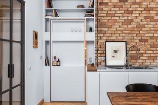 A Hidden Passageway Makes Each Room in This Berlin Flat a Private Destination - Photo 5 of 6 - A view of the pivoting shelf door from the kitchen and dining area.