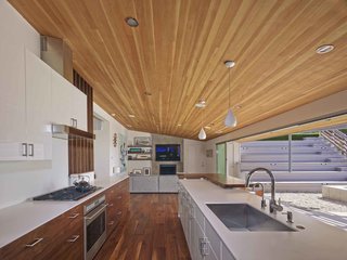 A Mid-Century Modern Makeover in Los Angeles - Photo 3 of 5 - "By removing a few interior walls, reconfiguring a couple of others and opening up the kitchen/living/dining areas, we were left with a wonderfully livable floor plan with a great balance of public and private space," says Southerland. A large, open galley style kitchen and mirrored planes of wall paneling visually expand the home's interior perspective.