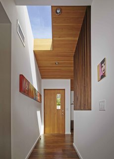 A Mid-Century Modern Makeover in Los Angeles - Photo 2 of 5 - Striated wood paneling and new skylights give light and dimension to the renovated entryway. 
