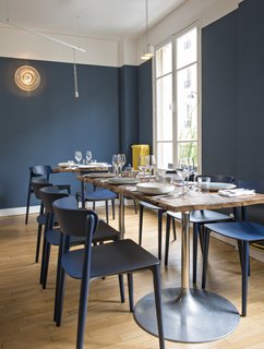 A Parisian Seafood Restaurant, Swimming in Shades of Blue - Photo 5 of 5 - Sixty-five seats are accommodated across Belle Maison's two floors. Bonaventure worked with craftsmen to create the custom chestnut-top tables; the circular wall sconces are vintage.