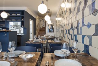 A Parisian Seafood Restaurant, Swimming in Shades of Blue - Photo 4 of 5 - The hand-painted ceramic tile wraps along the wall and continues up the stairwell. Named after Belle Maison, after the owners' favorite beach, the restaurant is focused on seafood dishes.