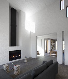 A Minimalist Retreat at the Edge of South Africa's Karoo Desert - Photo 2 of 6 - Soaring ceilings and a fireplace mark the home's main living area.