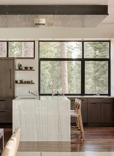 A Family's California Ski Retreat is Designed to Blend in With Its Site - Photo 3 of 5 - The dining area features ebonized quarter-sawn oak cabinetry with travertine work surfaces. 