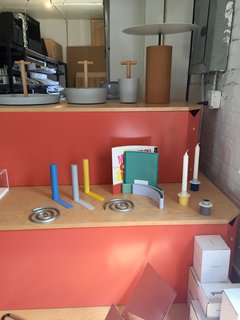 Inside the Designer's Studio: Good Thing - Photo 2 of 5 - A selection of Good Thing favorites, including the Slim bookends by Kenyon Yeh, Spiral trivet set and Paper Display by Sam Anderson and Jamie Wolfond, and Anderson's Field candle holders, sit side-by-side on a colorful display. 