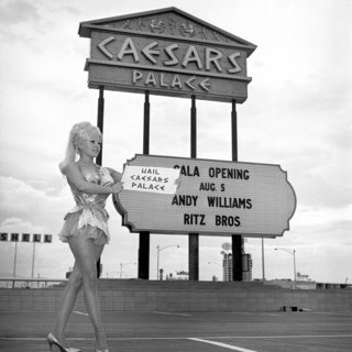 The Architecture of Excess: Caesars Palace at 50 - Photo 1 of 7 - A Caesars Palace employee poses by the themed marquee, created by Ad-Art based on a design by the famous Young Electric Sign Design Company, prior to the hotel's grand opening.