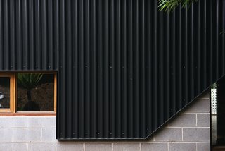 An Australian Renovation Gives New Life to Midcentury Style - Photo 8 of 14 - New black metal cladding joins cinderblock and wood-trimmed windows, two features more in line with the home's vintage. 