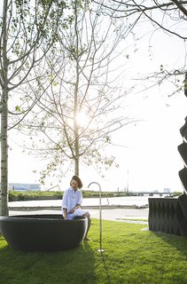 Stay in This 3D-Printed Tiny House - Photo 16 of 19 - A 3D-printed bathtub with a Vola spout sits within the pocket park.