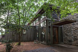 This Updated Breuer House Could Be Yours for a Cool $2.3 Million - Photo 3 of 3 - A glass-walled addition joins Marcel Breuer's minimalist Chamberlain Cottage. Part of the original house extends from the left of the structure. 