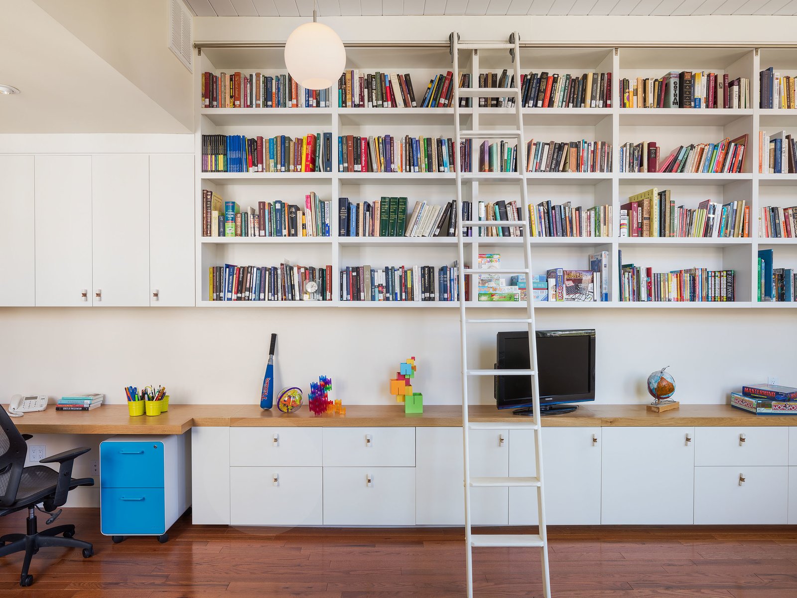 Philadelphia Row House Renovation - Photo 2 of 8 - A ladder leads to built-in book shelves.