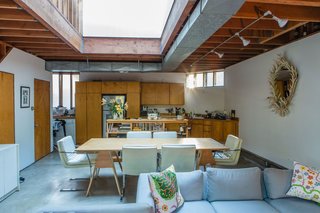Peek Inside the Frank Gehry Rental of an Emerging L.A. Furniture Designer - Photo 2 of 11 - When renting an apartment in Frank Gehry's Spiller House, Kristin Grant Fowler and William Fowler chose simple furnishing that relate back to the architect’s humble material palette. The tabletop is set on Burro Brand saw horses—the same ones Gehry uses in his office. The sofa was designed by Kristin's grandfather, Park Avenue interior designer Hector Grant; the mirror was also a gift from him. The cushions are by Josef Frank.